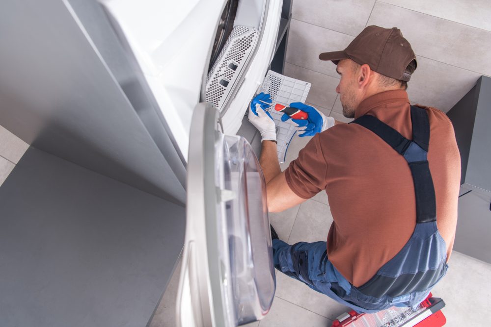 Professionnel qui nettoie les conduits d’une sécheuse chez un particulier.