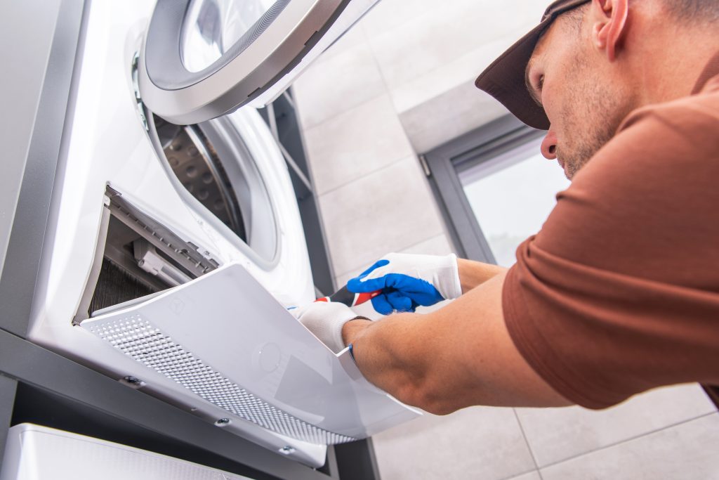 Professionnel qui nettoie les conduits d’une sécheuse chez un particulier.